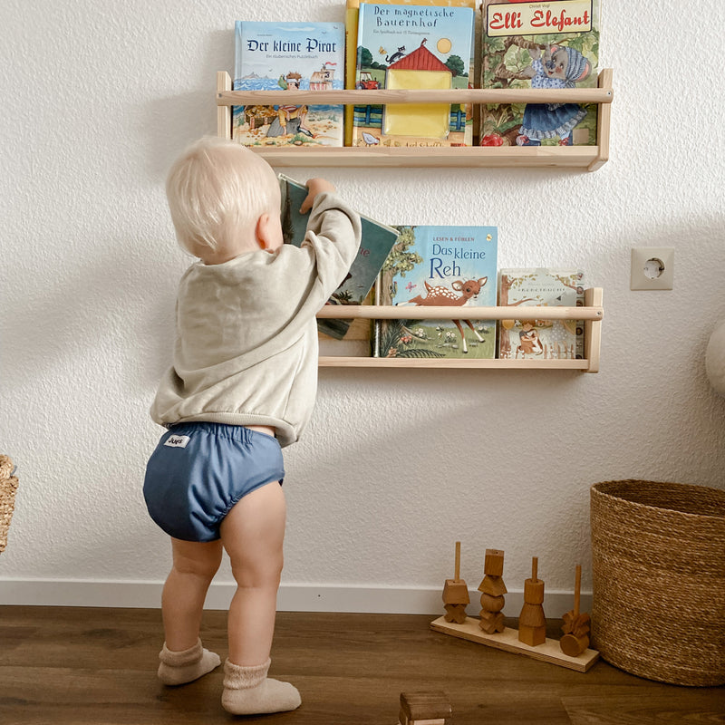 Judes Baby steht an Bücherregal nachhaltigkeit im kinderzimer