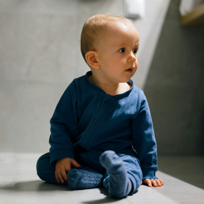 Baby mit Judes sitzt auf dem Boden